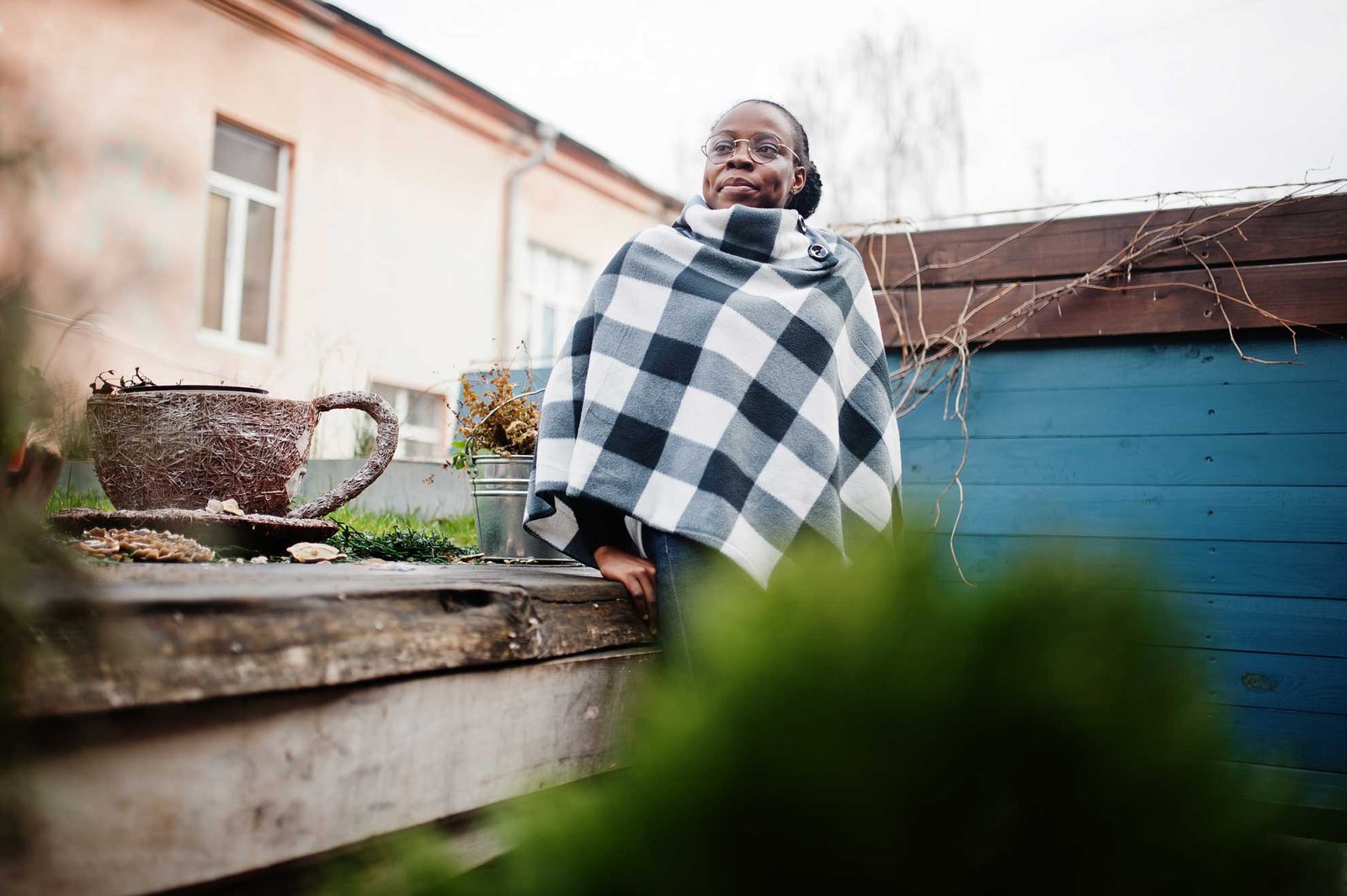 African woman in checkered cape posed outdoor.
